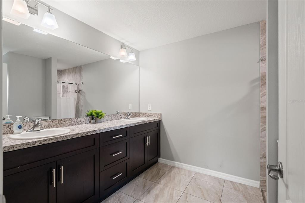 12015 Phoenix Avenue Weeki Wachee, FL 34614 - Photo 20 of 39 a bathroom with a double vanity sink and a mirror