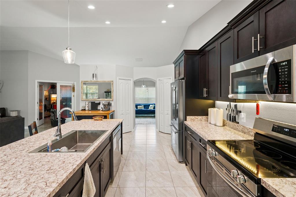 12015 Phoenix Avenue Weeki Wachee, FL 34614 - Photo 9 of 39 a kitchen with stainless steel appliances granite countertop a sink a stove and a refrigerator