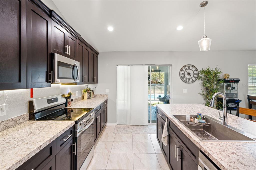 12015 Phoenix Avenue Weeki Wachee, FL 34614 - Photo 10 of 39 a kitchen with granite countertop stainless steel appliances and wooden cabinets