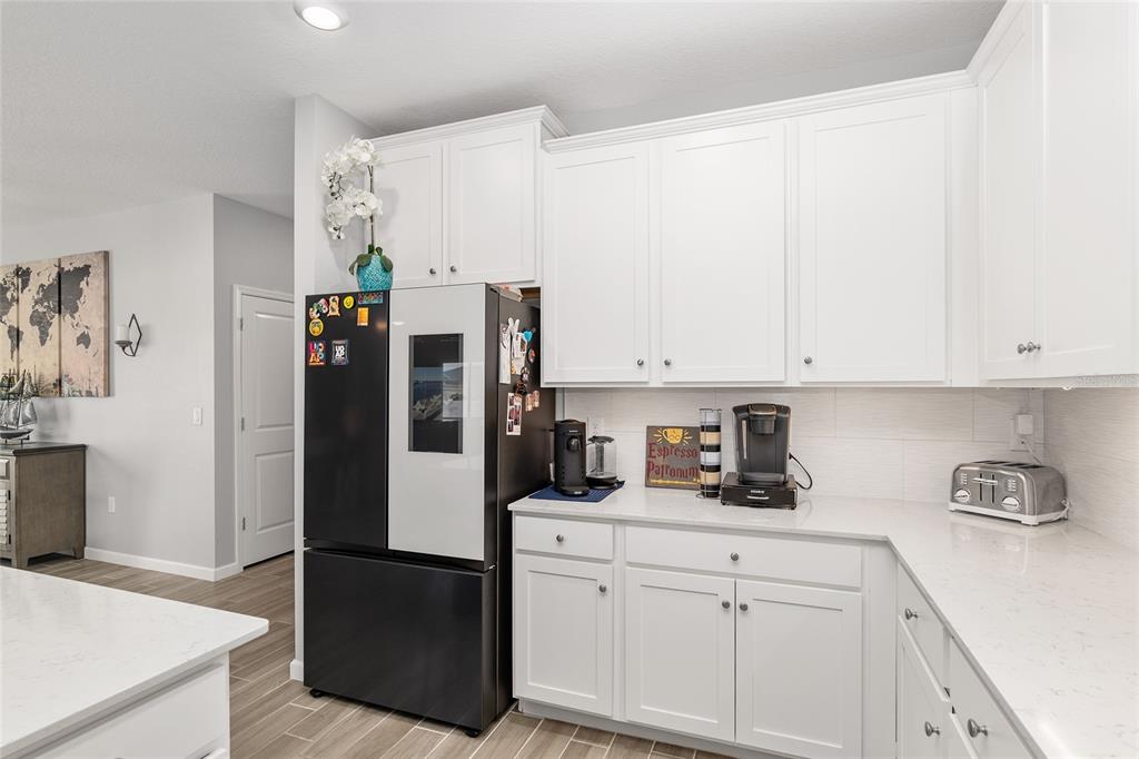 5688 Southwest 92nd Place Ocala, FL 34476 - Photo 24 of 54 a kitchen with stainless steel appliances white cabinets and a refrigerator