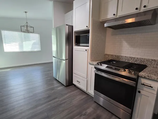 a kitchen with wooden floors and stainless steel appliances