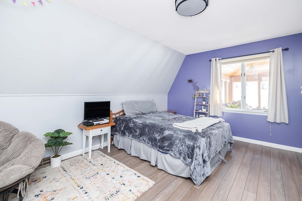 49 Red Bridge Road Wilbraham, MA 01095 - Photo 19 of 40 a bedroom with a bed wooden floor and a flat screen tv
