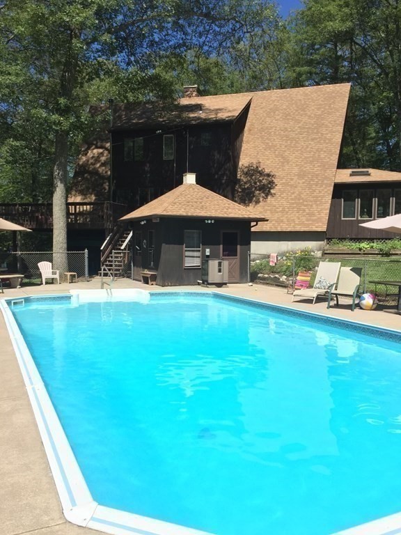 49 Red Bridge Road Wilbraham, MA 01095 - Photo 2 of 40 a view of swimming pool with lawn chairs under an umbrella
