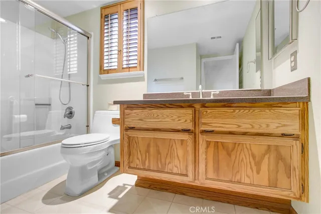 a view of a house with a big yard potted plants and a palm tree