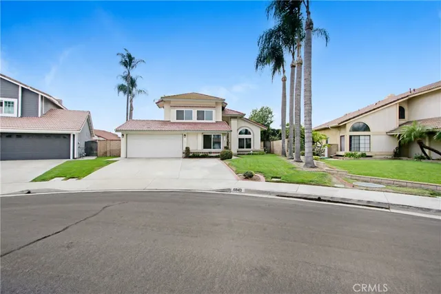 a view of a house with a yard and palm trees