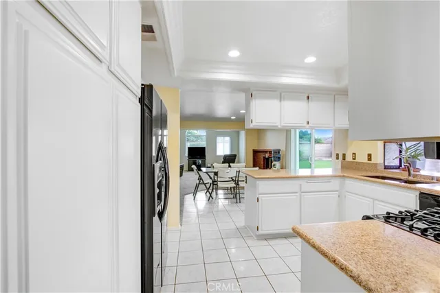 a kitchen with a sink a stove and chairs