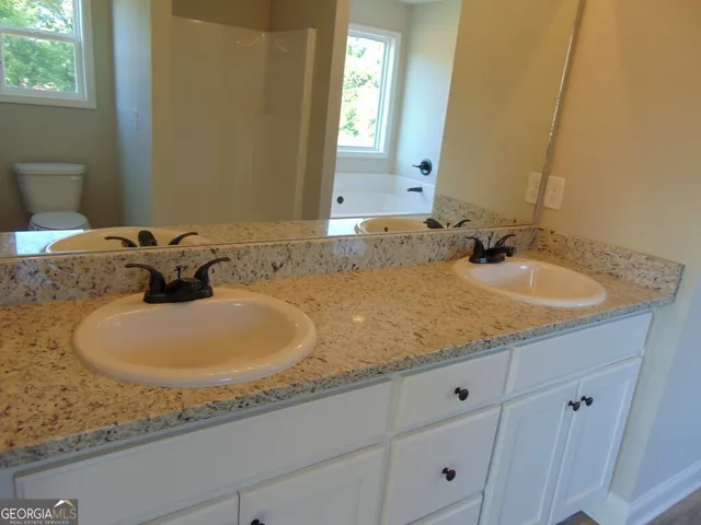 a bathroom with a granite countertop sink and mirror