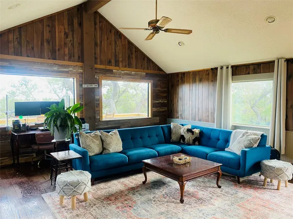 a living room with furniture a ceiling fan and a window