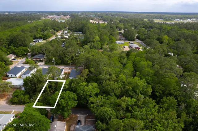 an aerial view of residential houses with outdoor space and trees