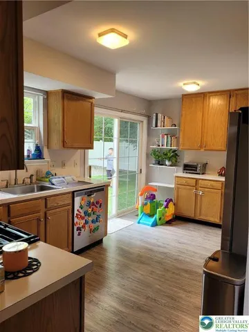 a kitchen that has a lot of cabinets a sink and a wooden floor