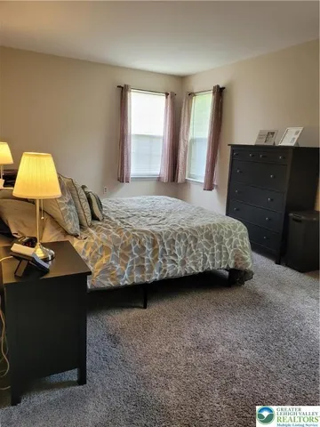 a bedroom with a bed and a lamp on dresser