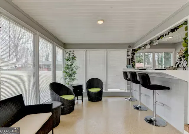 a living room with furniture and floor to ceiling windows