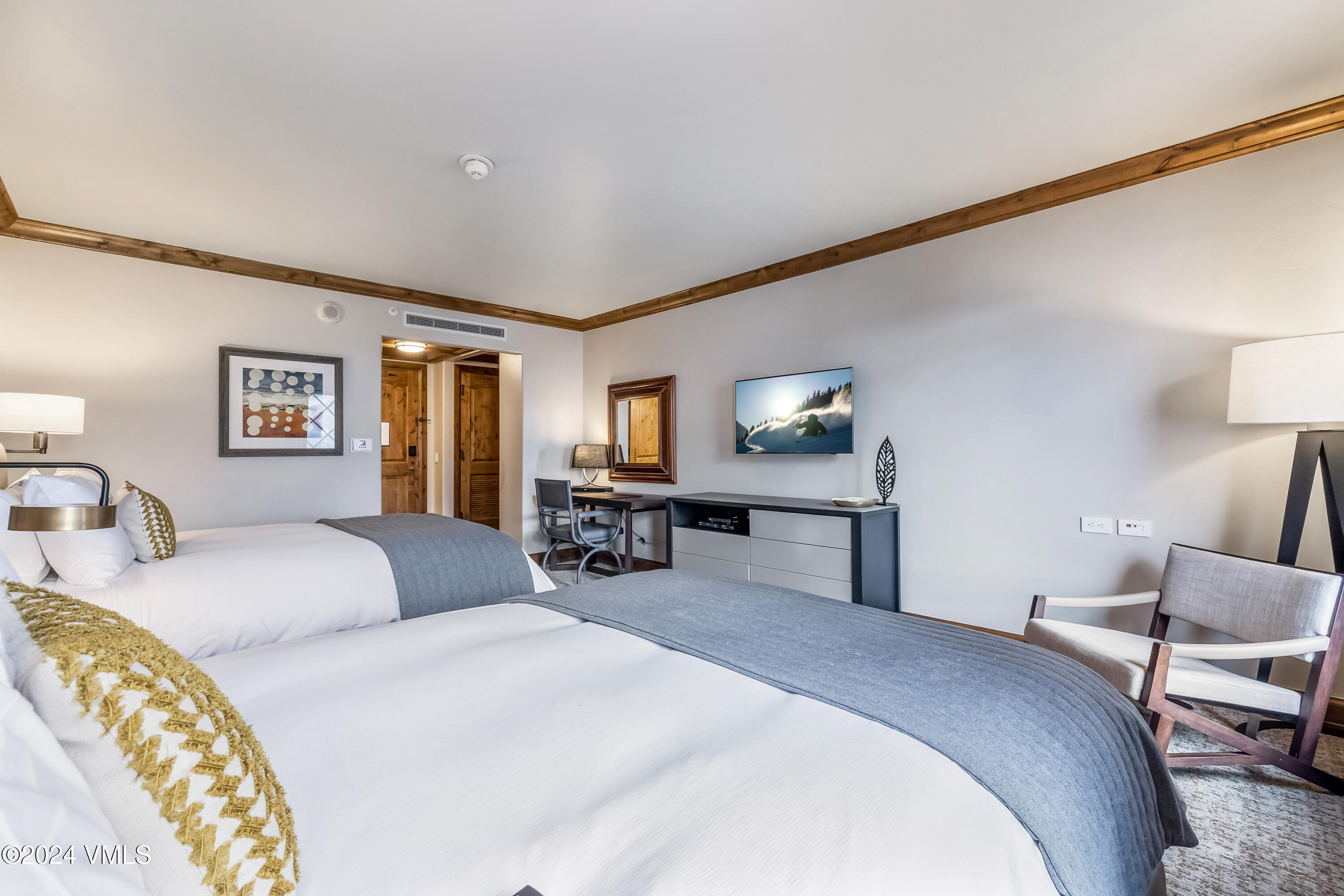 16 Vail Road Vail, CO 81657 - Photo 18 of 36 a spacious bedroom with a bed a mirror and lamp