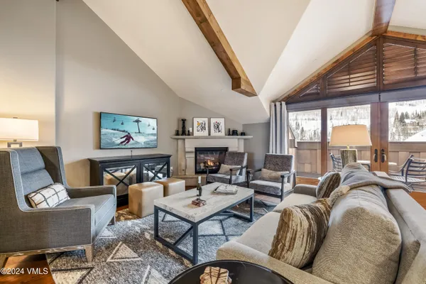 a living room with fireplace furniture and a large window