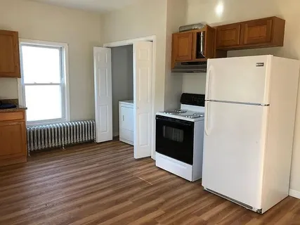 a white refrigerator freezer and a stove sitting inside of a kitchen