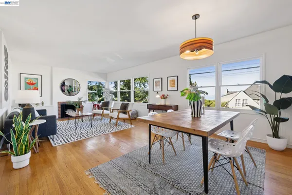 a view of a dining room and livingroom with furniture wooden floor a rug and a clock