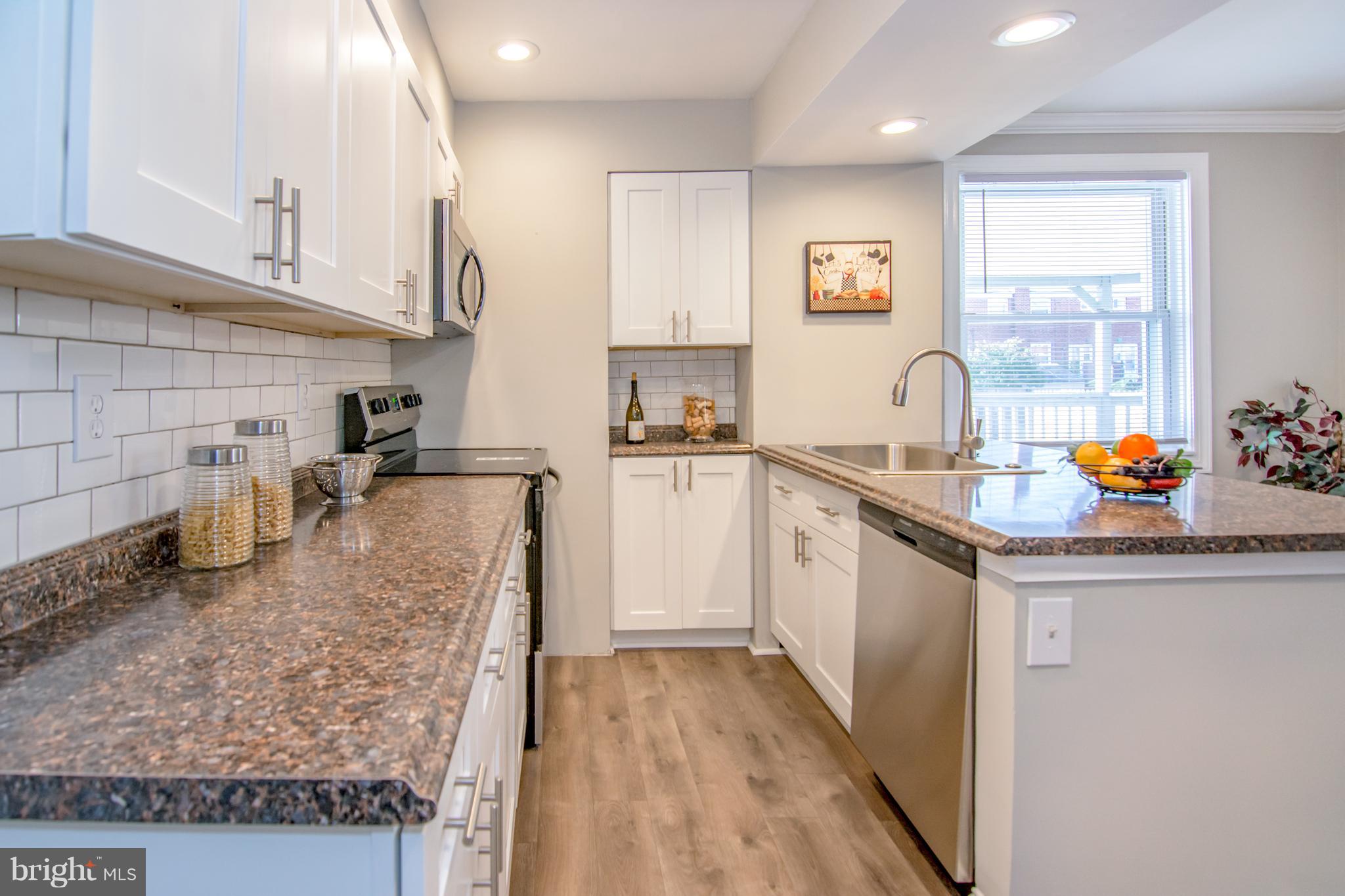 2056 Jasmine Road Dundalk, MD 21222 - Photo 13 of 30 a kitchen with stainless steel appliances granite countertop a sink stove and refrigerator