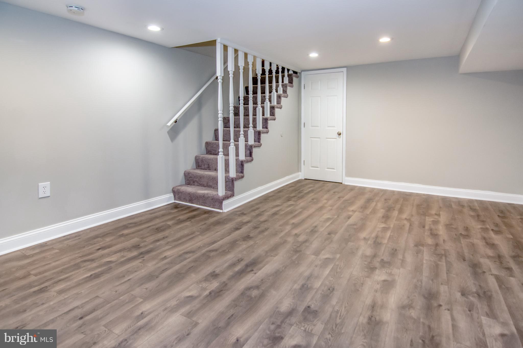 2056 Jasmine Road Dundalk, MD 21222 - Photo 22 of 30 an empty room with wooden floor and staircase