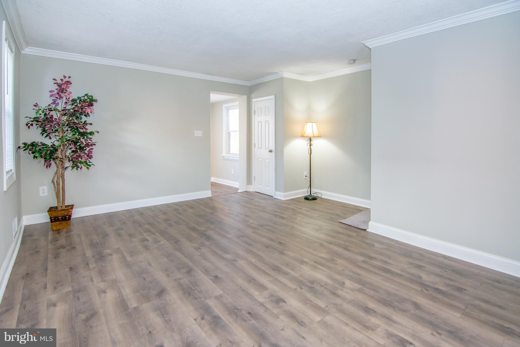 2056 Jasmine Road Dundalk, MD 21222 - Photo 6 of 30 an empty room with wooden floor and a potted plant