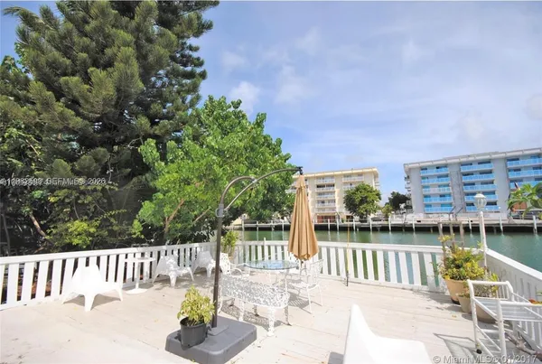 a view of a chair and tables on the lake