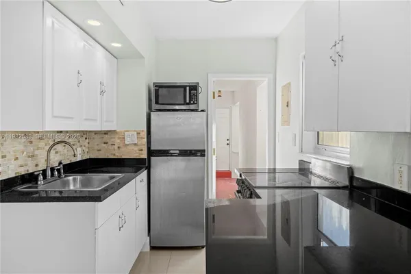 a kitchen with kitchen island a sink stove and refrigerator