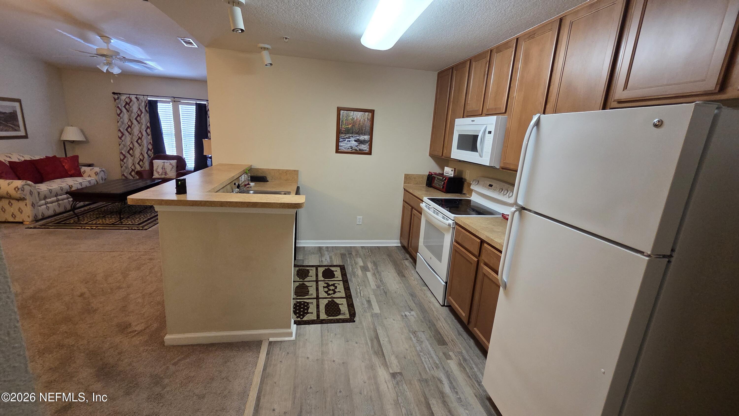 9400 Underwing Way, Unit 9 Jacksonville, FL 32257 - Photo 18 of 30 a kitchen with a refrigerator a stove top oven a sink and dishwasher