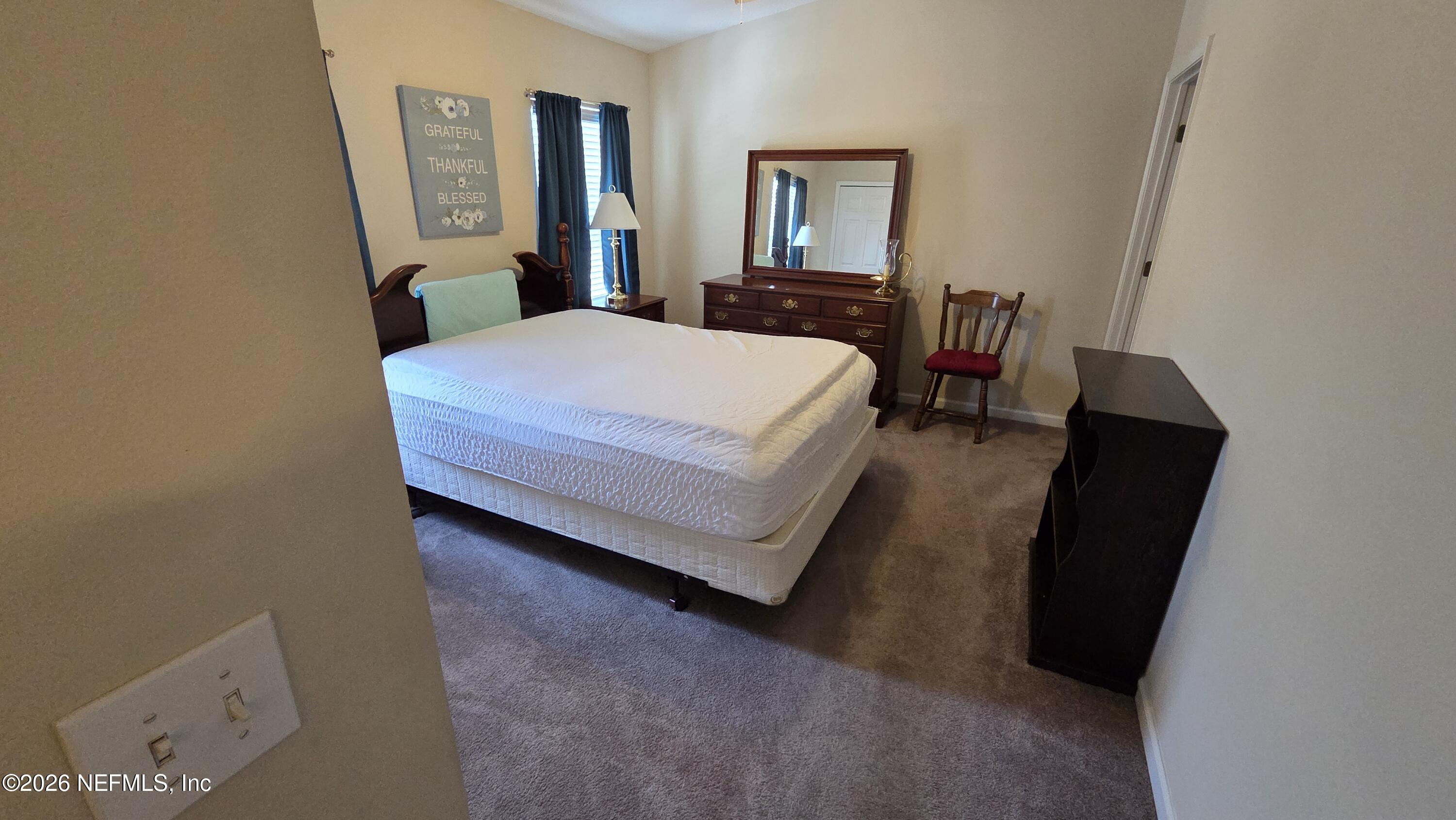 9400 Underwing Way, Unit 9 Jacksonville, FL 32257 - Photo 23 of 30 a bedroom with a bed and a mirror