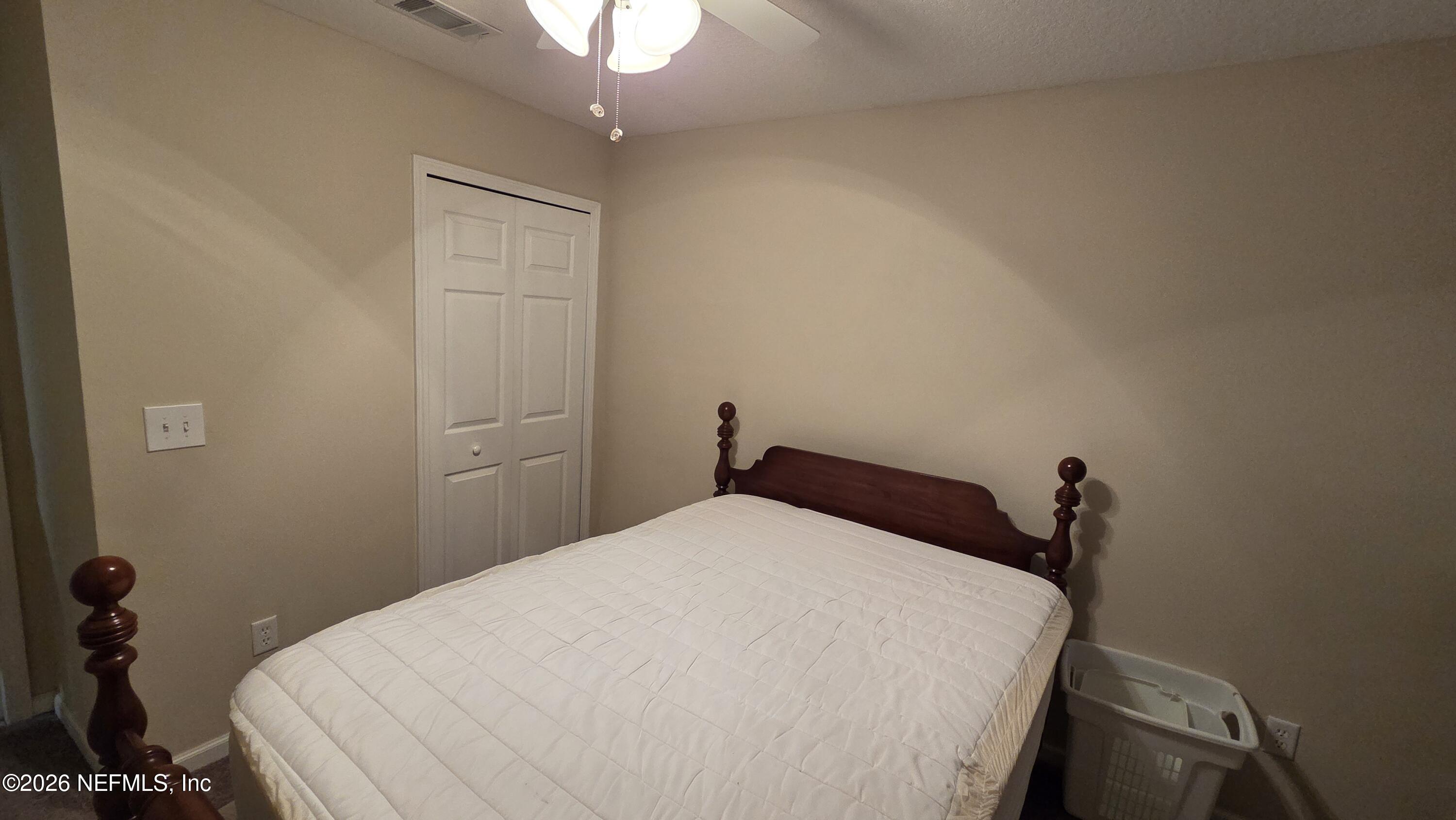 9400 Underwing Way, Unit 9 Jacksonville, FL 32257 - Photo 29 of 30 a bedroom with a bed and a chandelier fan