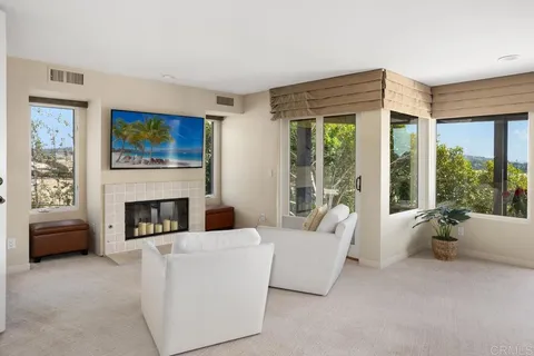 a living room with furniture a fireplace and a large window