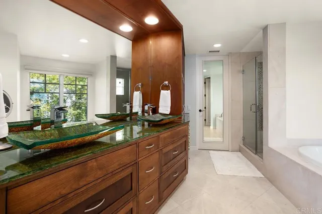 a bathroom with a granite countertop sink a large mirror and a bathtub