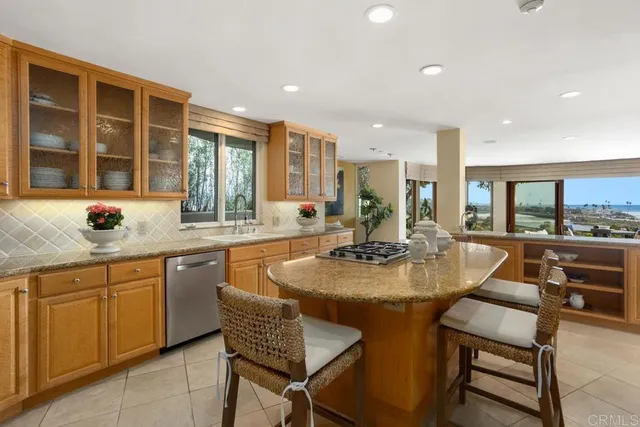 a dining hall with stainless steel appliances granite countertop a table and chairs