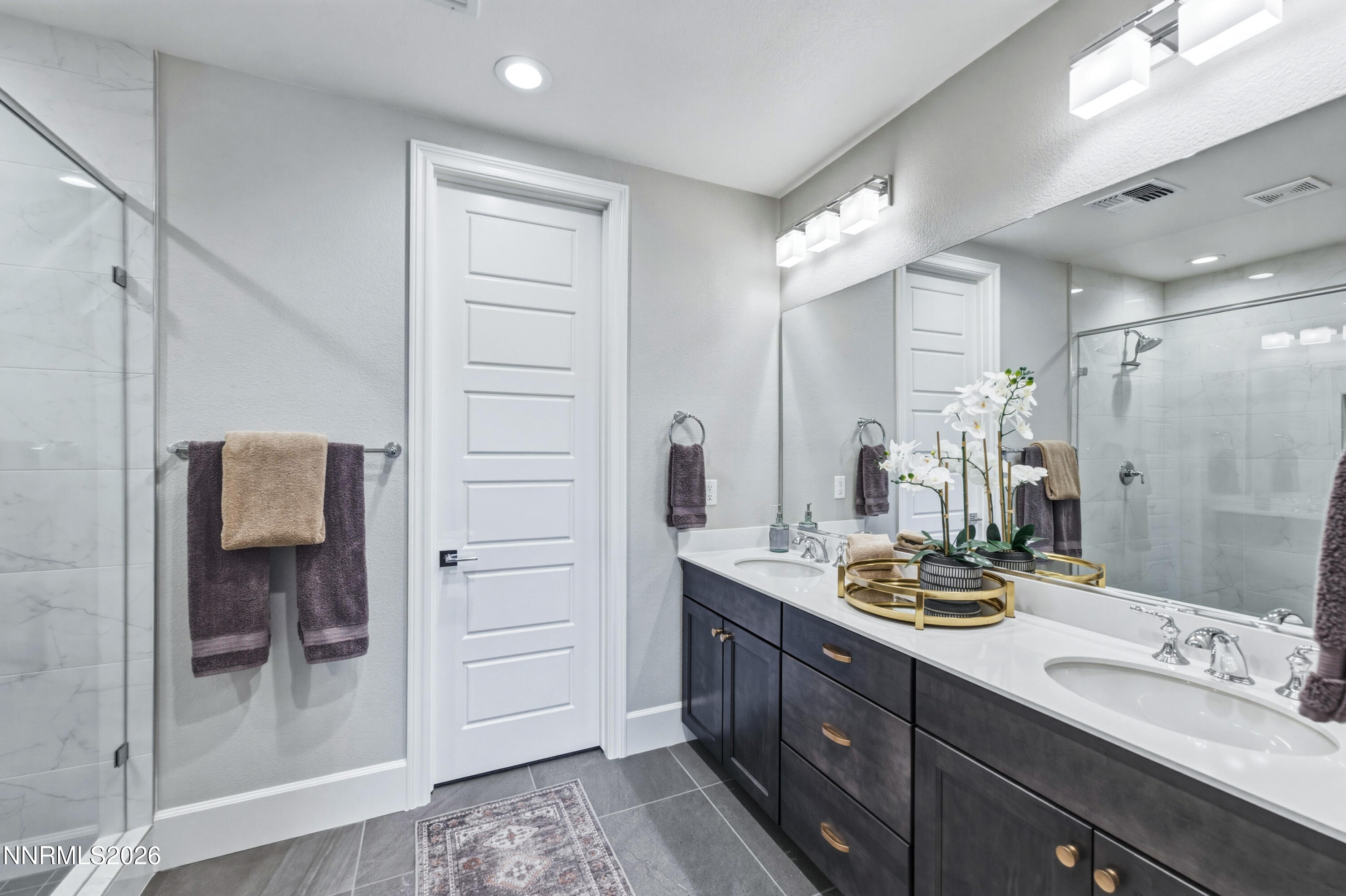 9028 Iron Sky Court Reno, NV 89523 - Photo 24 of 36 a bathroom with a double vanity sink mirror and shower