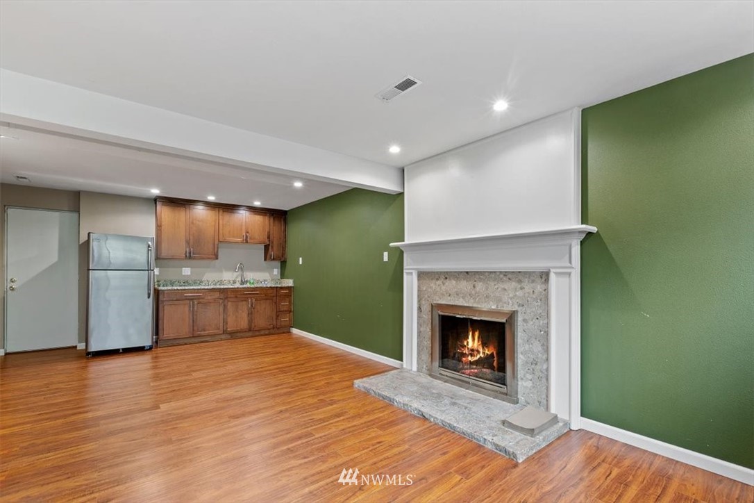 12656 177th Place Southeast Renton, WA 98059 - Photo 21 of 27 a large white kitchen with a fireplace and wooden floor