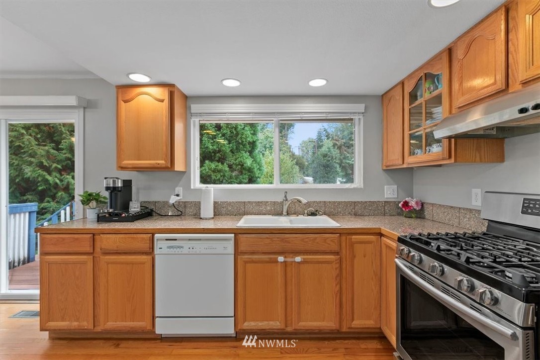 12656 177th Place Southeast Renton, WA 98059 - Photo 9 of 27 a kitchen with stainless steel appliances granite countertop a stove a sink and a microwave