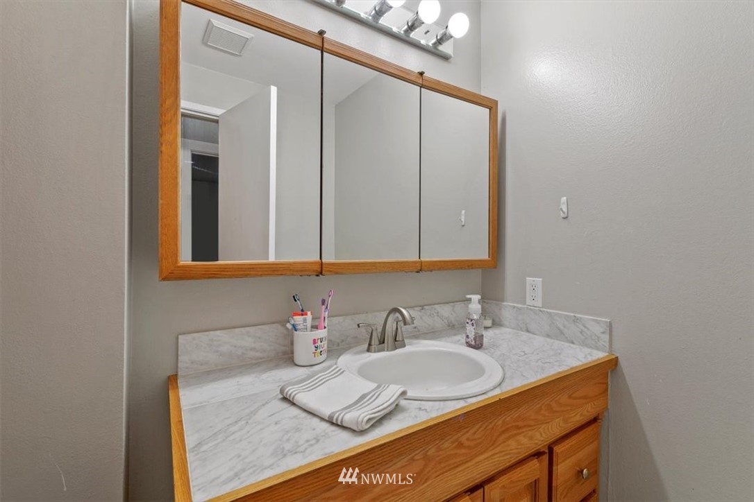12656 177th Place Southeast Renton, WA 98059 - Photo 10 of 27 a bathroom with a granite countertop sink and a mirror