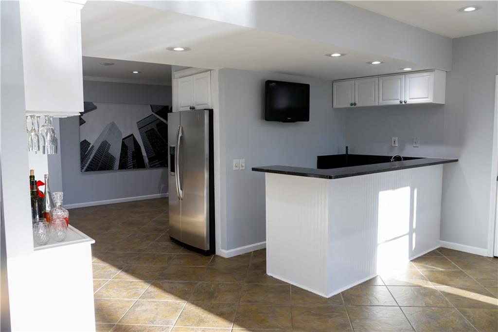 523 Waterside Court Canton, GA 30114 - Photo 20 of 28 a kitchen with stainless steel appliances kitchen island a refrigerator sink and microwave