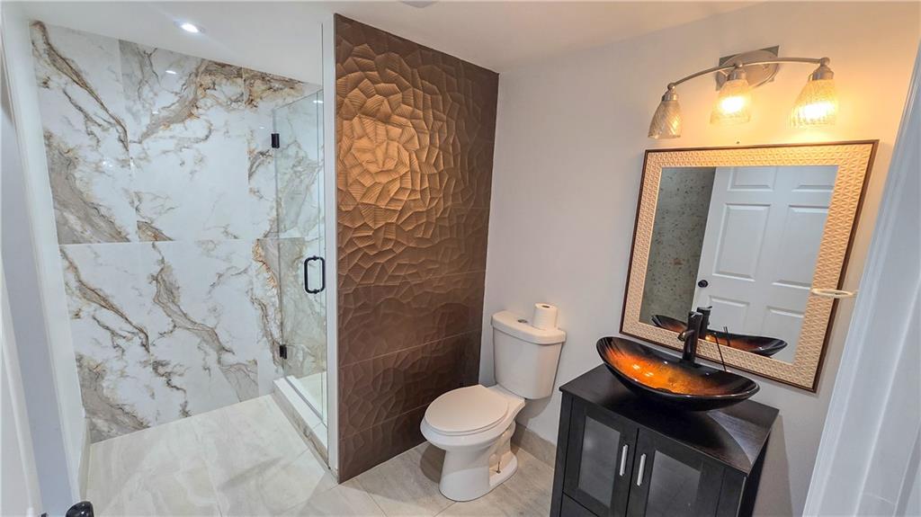 523 Waterside Court Canton, GA 30114 - Photo 22 of 28 a bathroom with a toilet sink vanity shower and mirror