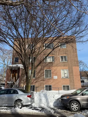 a car parked in front of a brick house