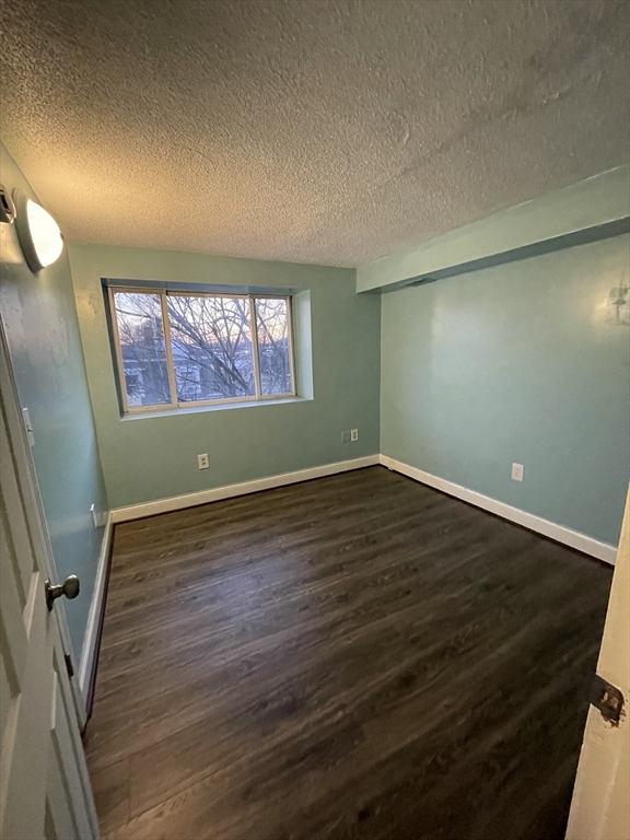 85 Munroe Street Boston, MA 02119 - Photo 11 of 15 an empty room with wooden floor and windows