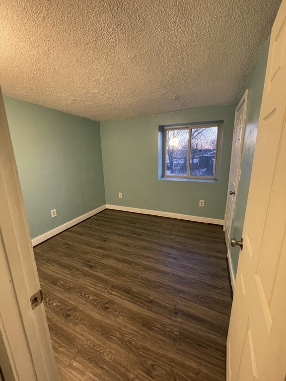 85 Munroe Street Boston, MA 02119 - Photo 13 of 15 an empty room with wooden floor and window