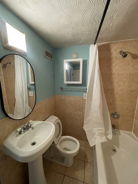 85 Munroe Street Boston, MA 02119 - Photo 14 of 15 a bathroom with a sink toilet and mirror