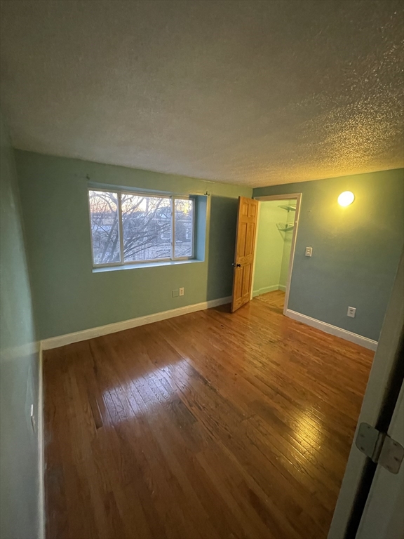 85 Munroe Street Boston, MA 02119 - Photo 9 of 15 an empty room with wooden floor and windows