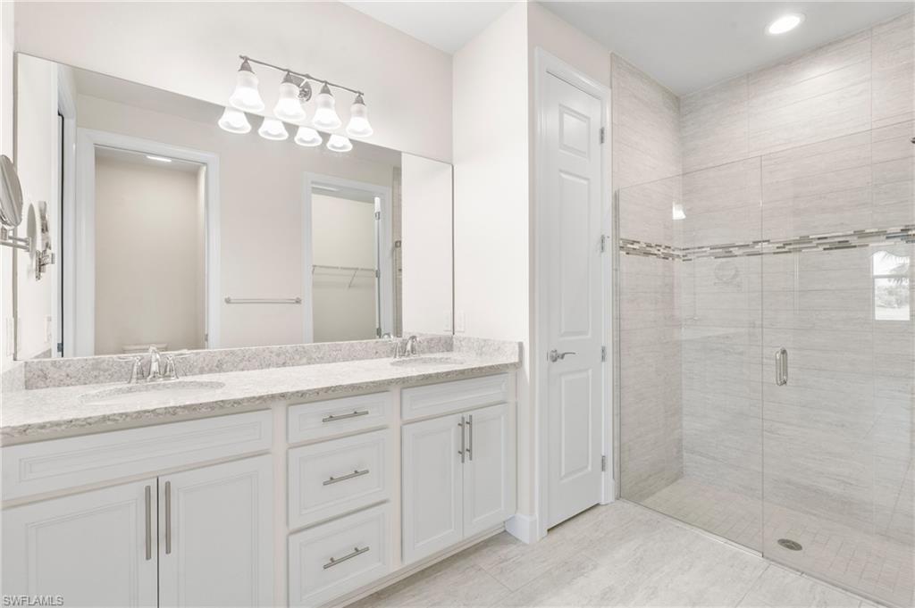 20128 Torch Key Way Estero, FL 33928 - Photo 13 of 50 a bathroom with a granite countertop sink a mirror and a shower