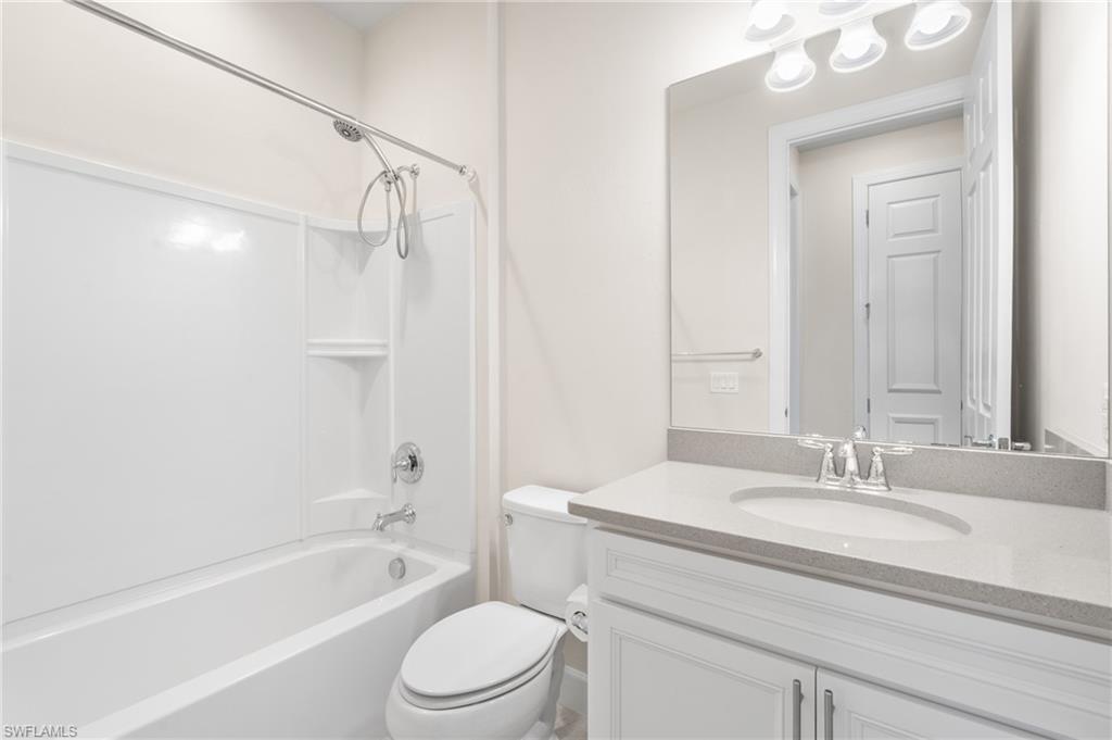 20128 Torch Key Way Estero, FL 33928 - Photo 18 of 50 a bathroom with a granite countertop sink a toilet and shower