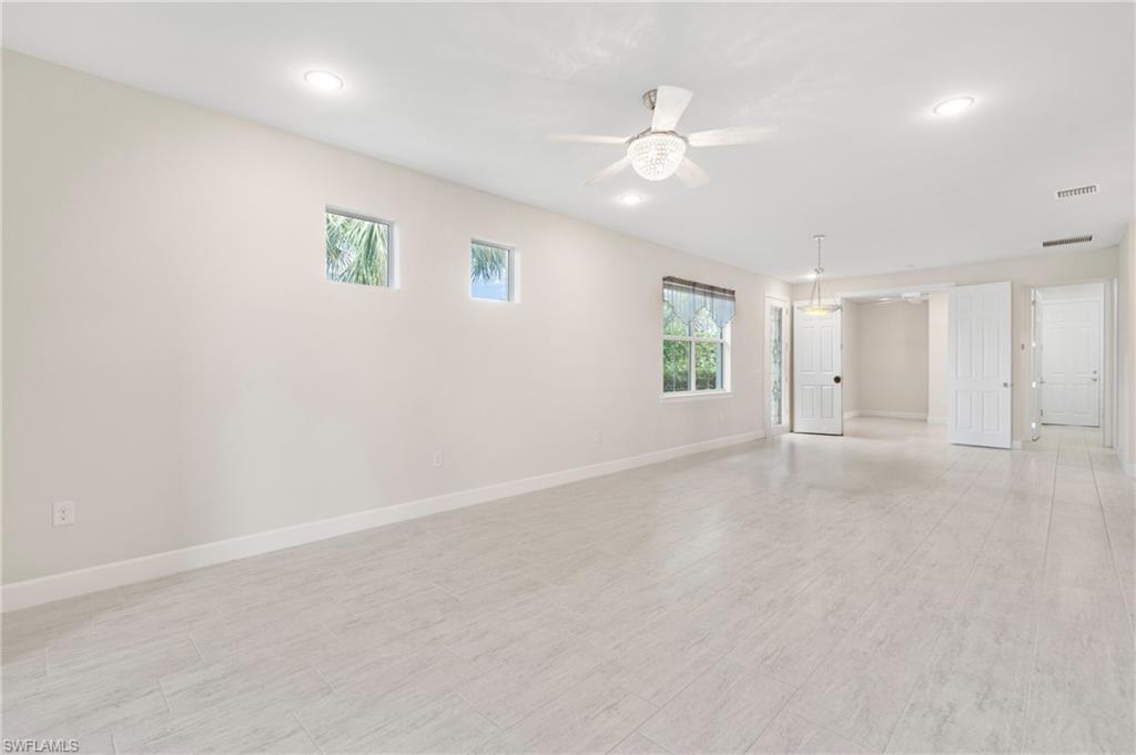 20128 Torch Key Way Estero, FL 33928 - Photo 5 of 50 an empty room with a chandelier fan and windows