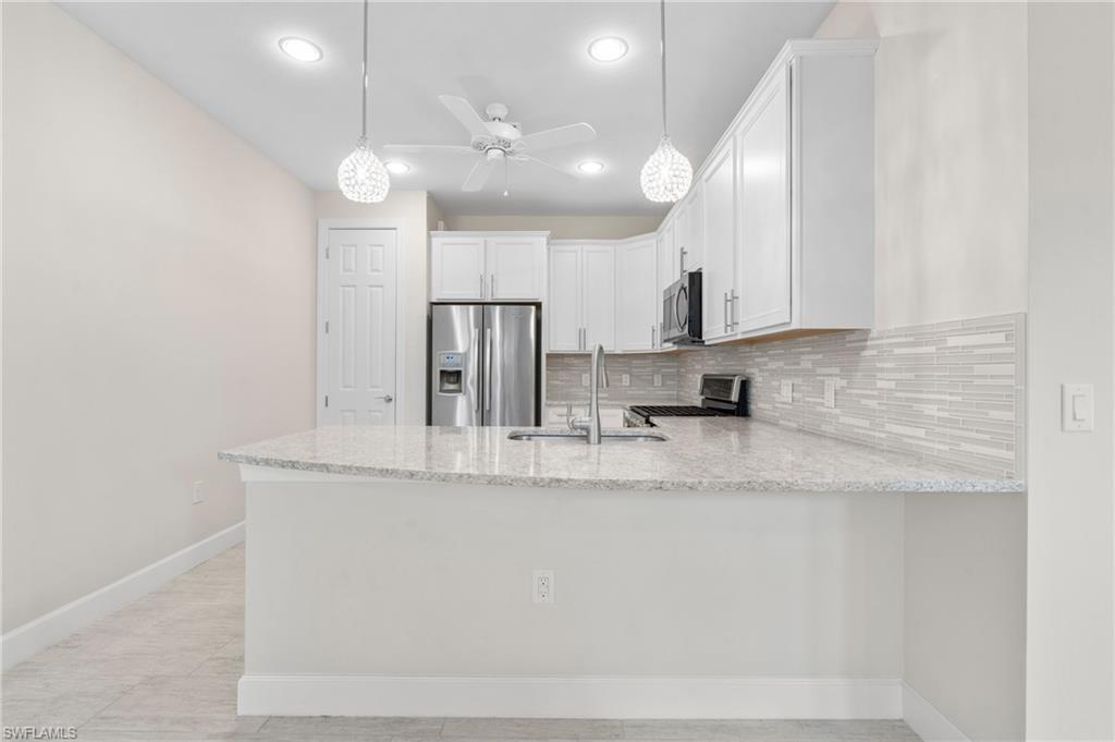 20128 Torch Key Way Estero, FL 33928 - Photo 7 of 50 a kitchen with stainless steel appliances granite countertop a sink a refrigerator and a granite counter tops