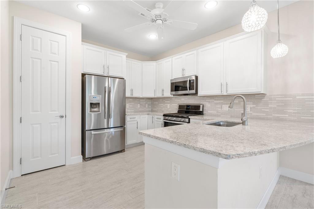 20128 Torch Key Way Estero, FL 33928 - Photo 8 of 50 a kitchen with stainless steel appliances granite countertop a refrigerator a sink a stove a microwave and island