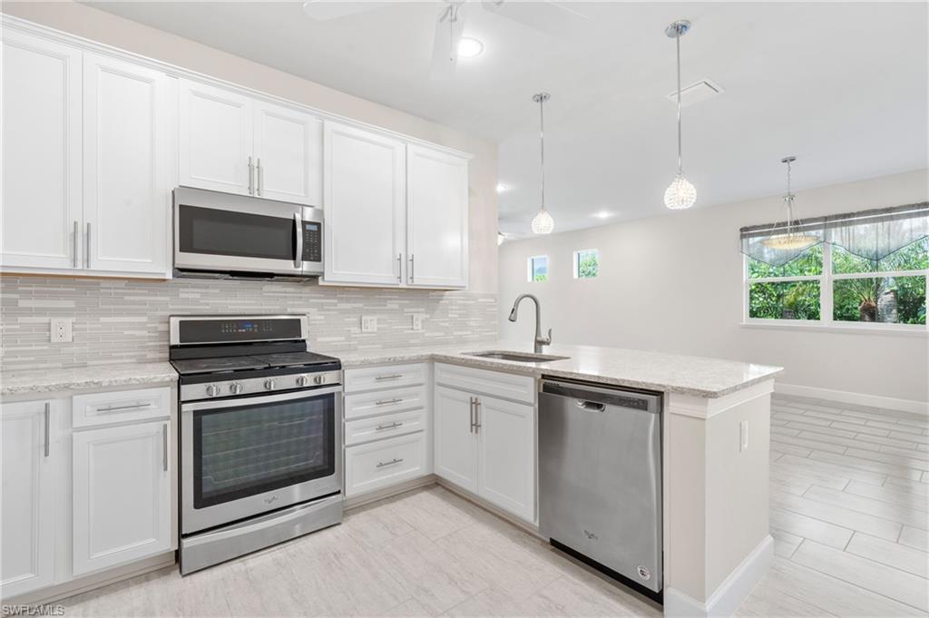 20128 Torch Key Way Estero, FL 33928 - Photo 9 of 50 a kitchen with a stove and a microwave