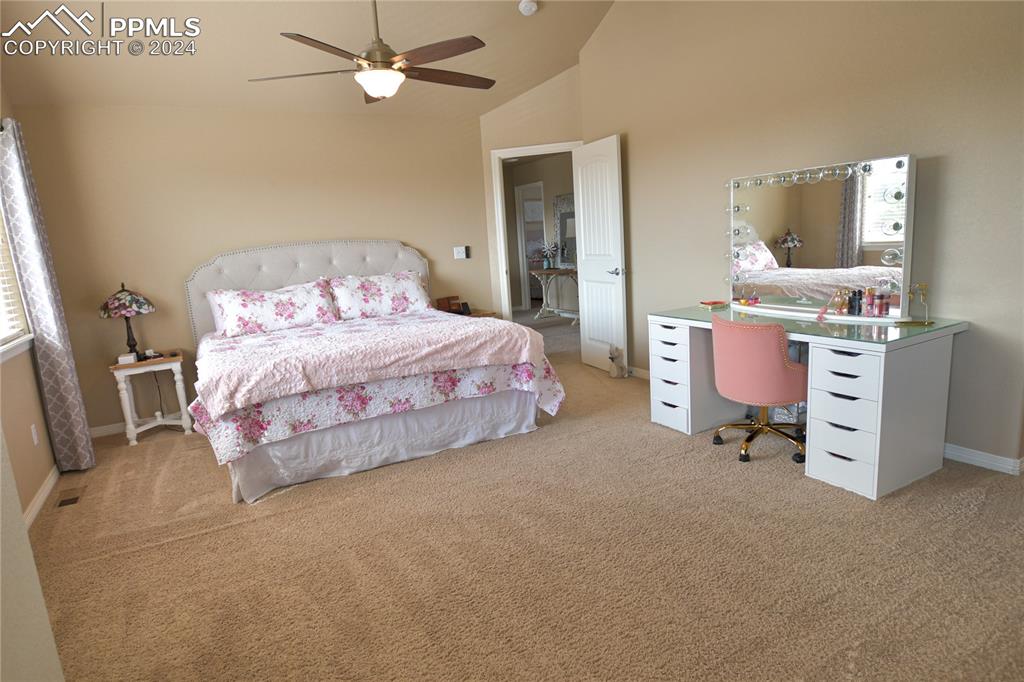 6290 Bearcat Loop Colorado Springs, CO 80925 - Photo 27 of 49 a bedroom with a bed and a chandelier