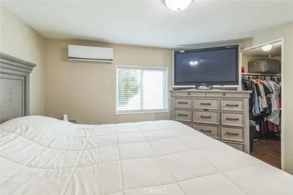 a bedroom with a large bed and a flat screen tv